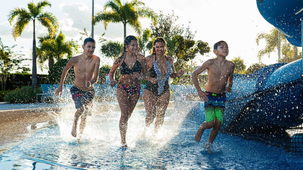 A group of kids running and splashing through the Encore Resort Water Park.
