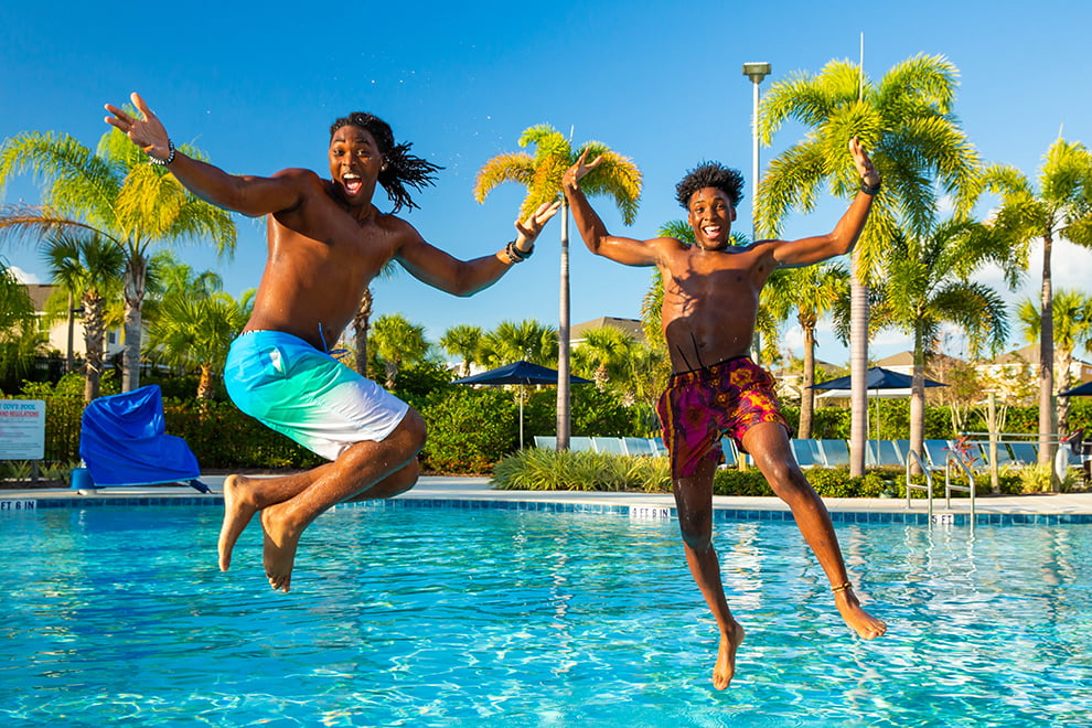 Two young men jump into the Encore Resort Water Park swimming pool.