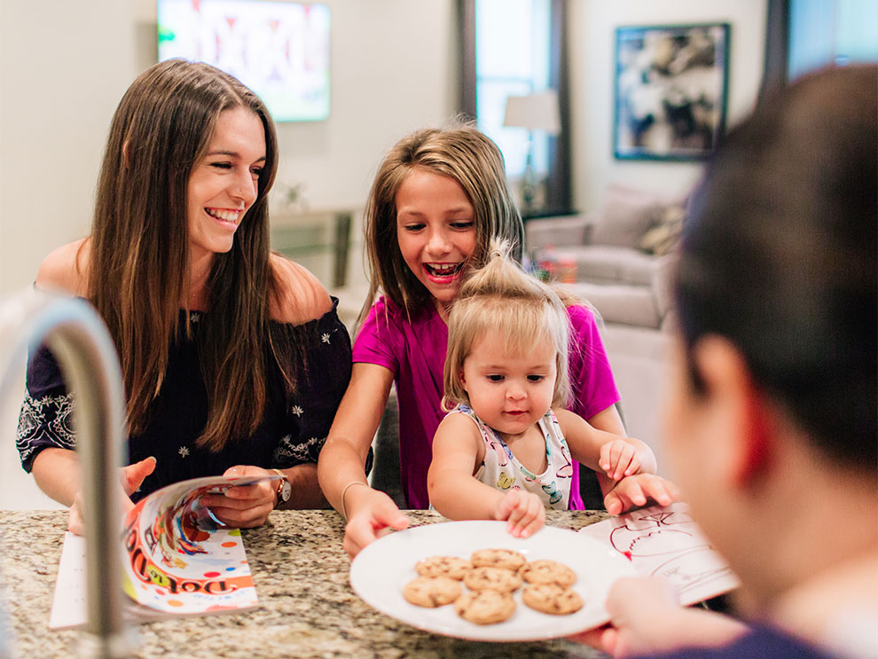 Family of sisters share a plate of cookies while gathered together inside their Encore Resort vacation residence.