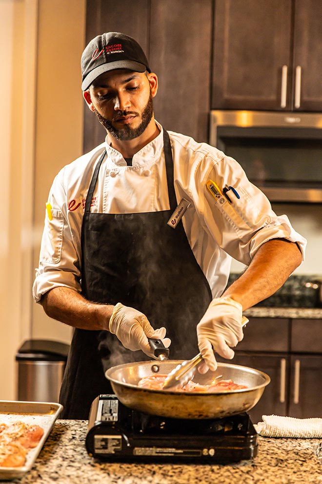 An Encore Resort expert chef cooks during an in-home chef experience inside a curated resort residence.