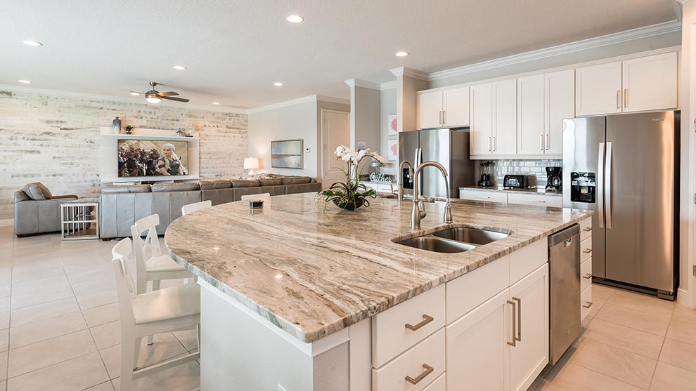 Furnished kitchen with island sink and barstool seating inside a curated Encore Resort residence.
