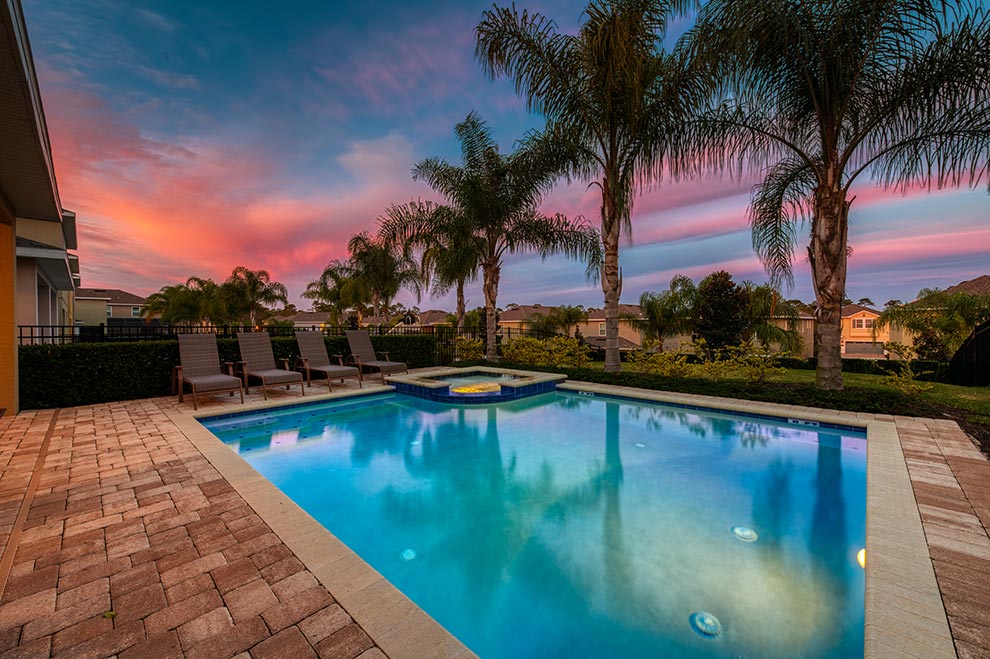 Backyard pool at a curated Encore Resort residence with underwater lighting at sunset.