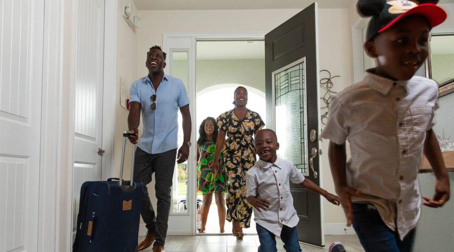 Kids run excitedly into their Encore Resort residence as their family arrives on their vacation.