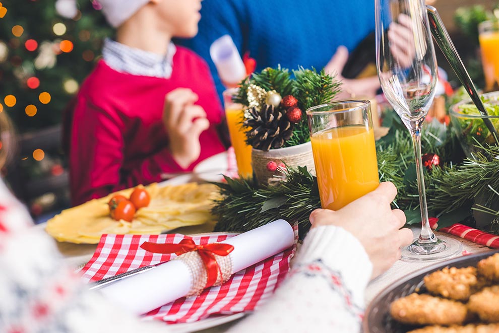 Family gathered together for Christmas dinner at a table with decorations for the holidays.