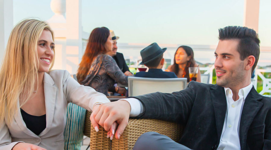 Couple holding hands on a date on the Encore Resort Clubhouse’s third-floor terrace.