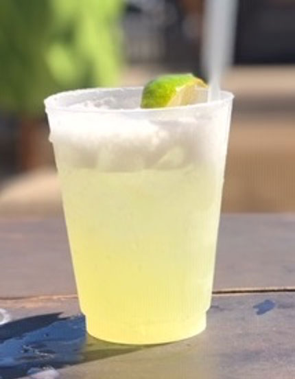 Agave margarita cocktail in a cup garnished with a lime.