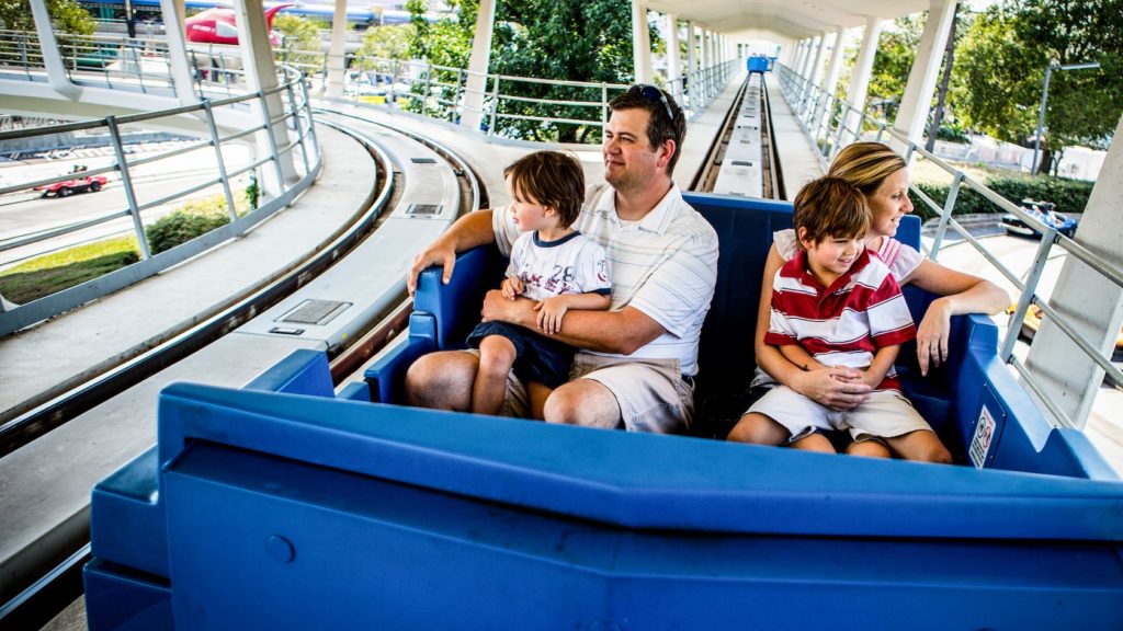 Family riding the PeopleMover ride at Disney's Magic Kingdom.