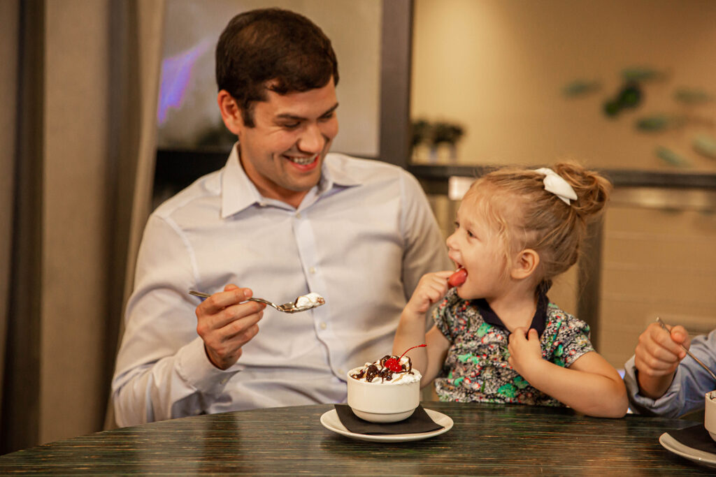 Father and daughter sharing an ice cream sundae