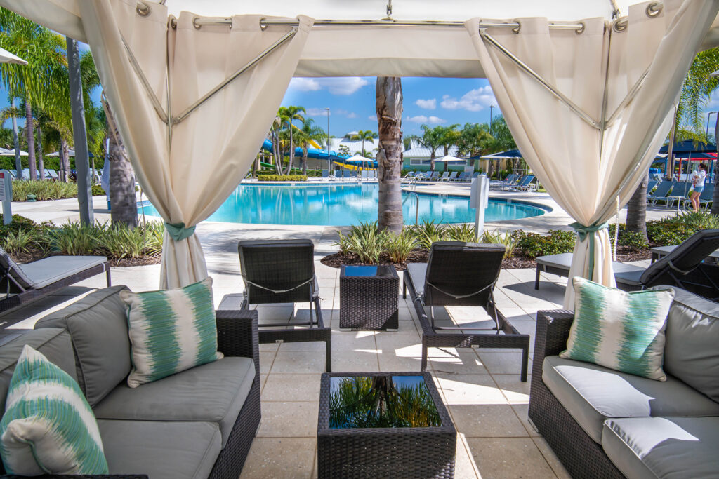 Cabana filled with lounge furniture by the pool