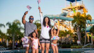 Family at a water park waving American flags