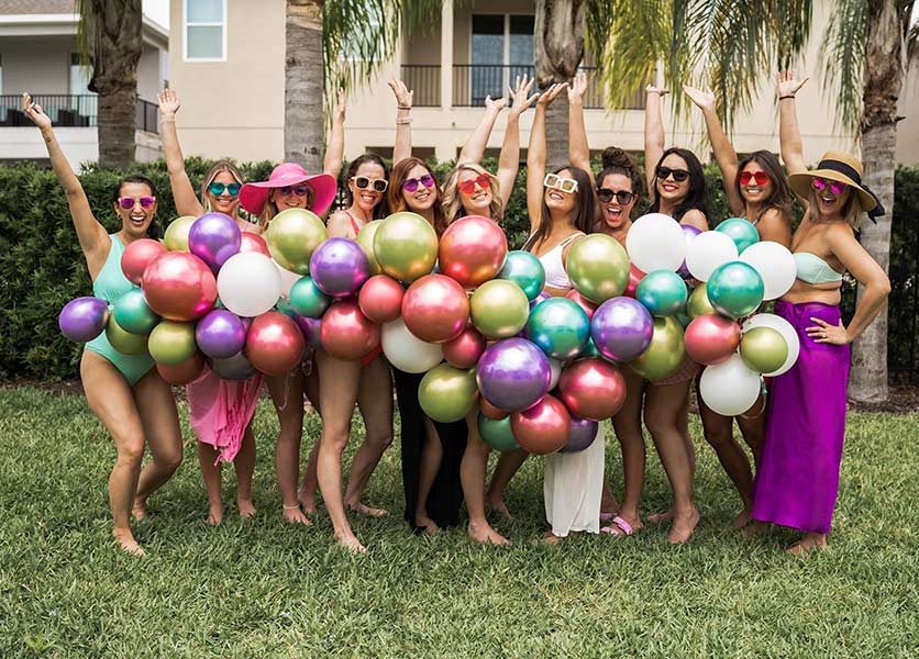 Group of women with multi-colored balloons at a bachelorette party