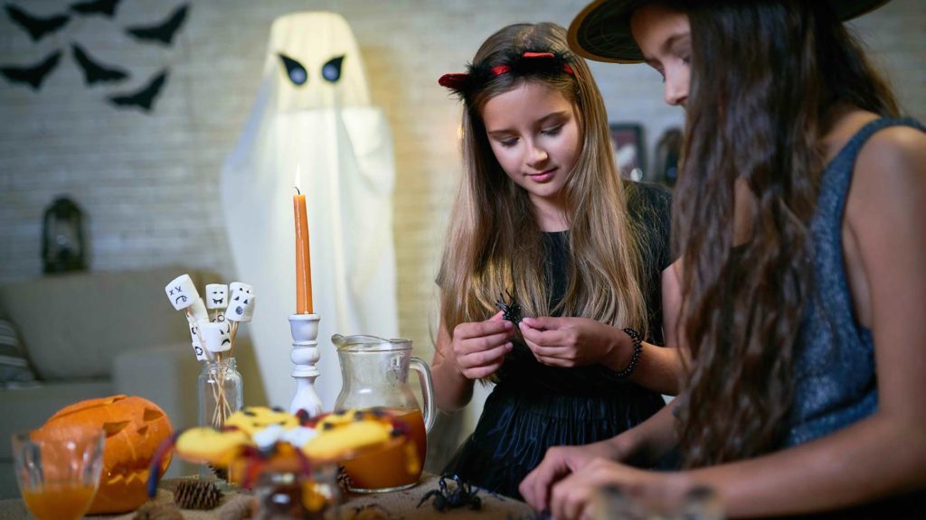 Young girls creating Halloween inspired DIY crafts