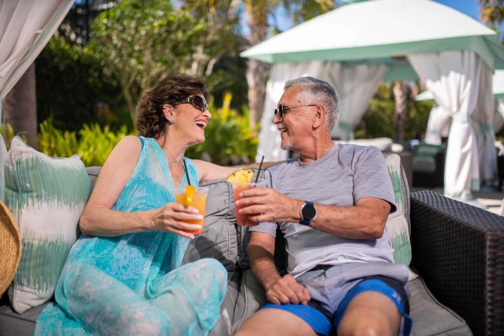 Older couple enjoying cocktails in their private cabana at the Encore Resort water park